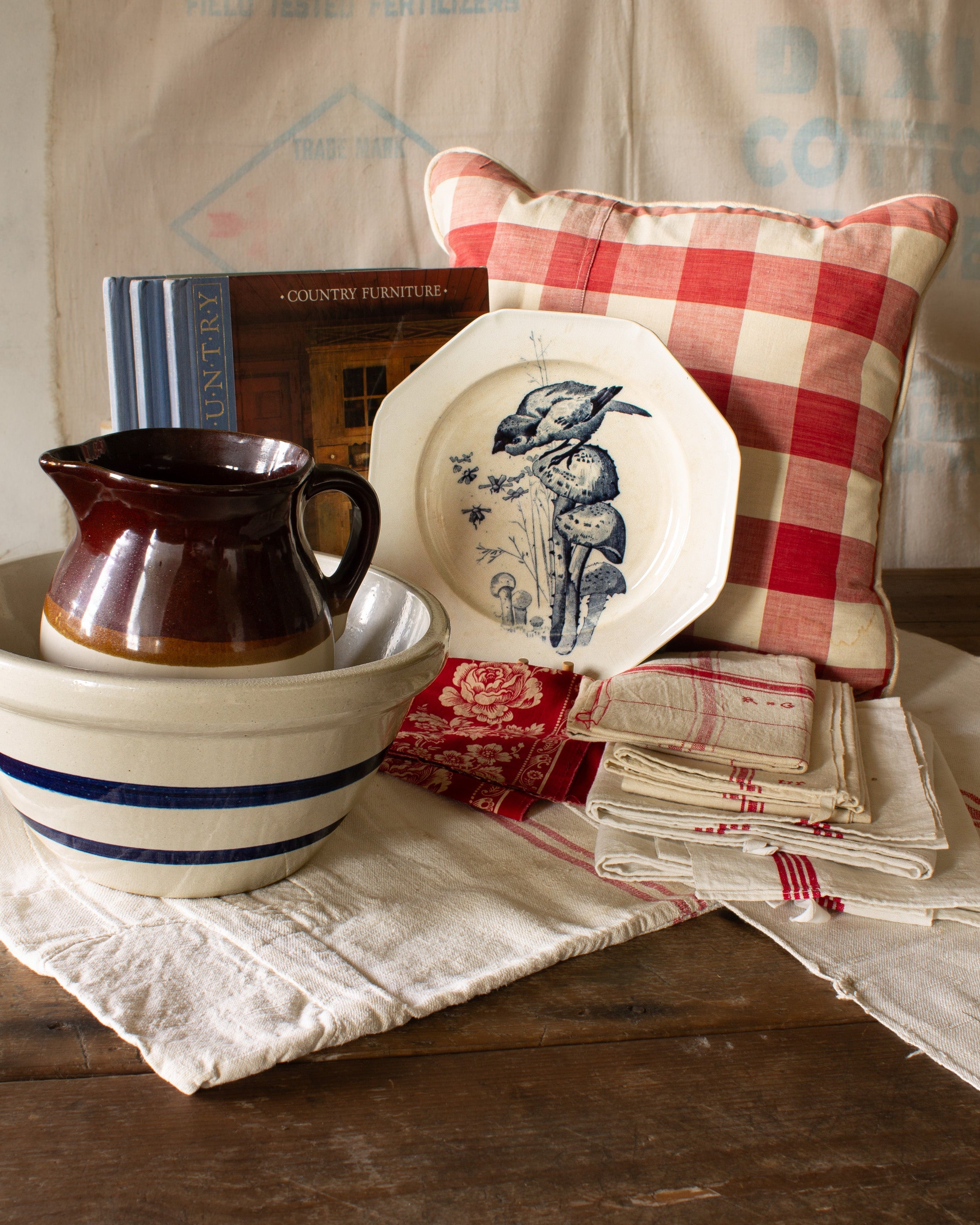 The Linen & the Land collection header featuring antique French Vichy check linen, blue and white transferware, and striped stoneware styled for a collected country home.