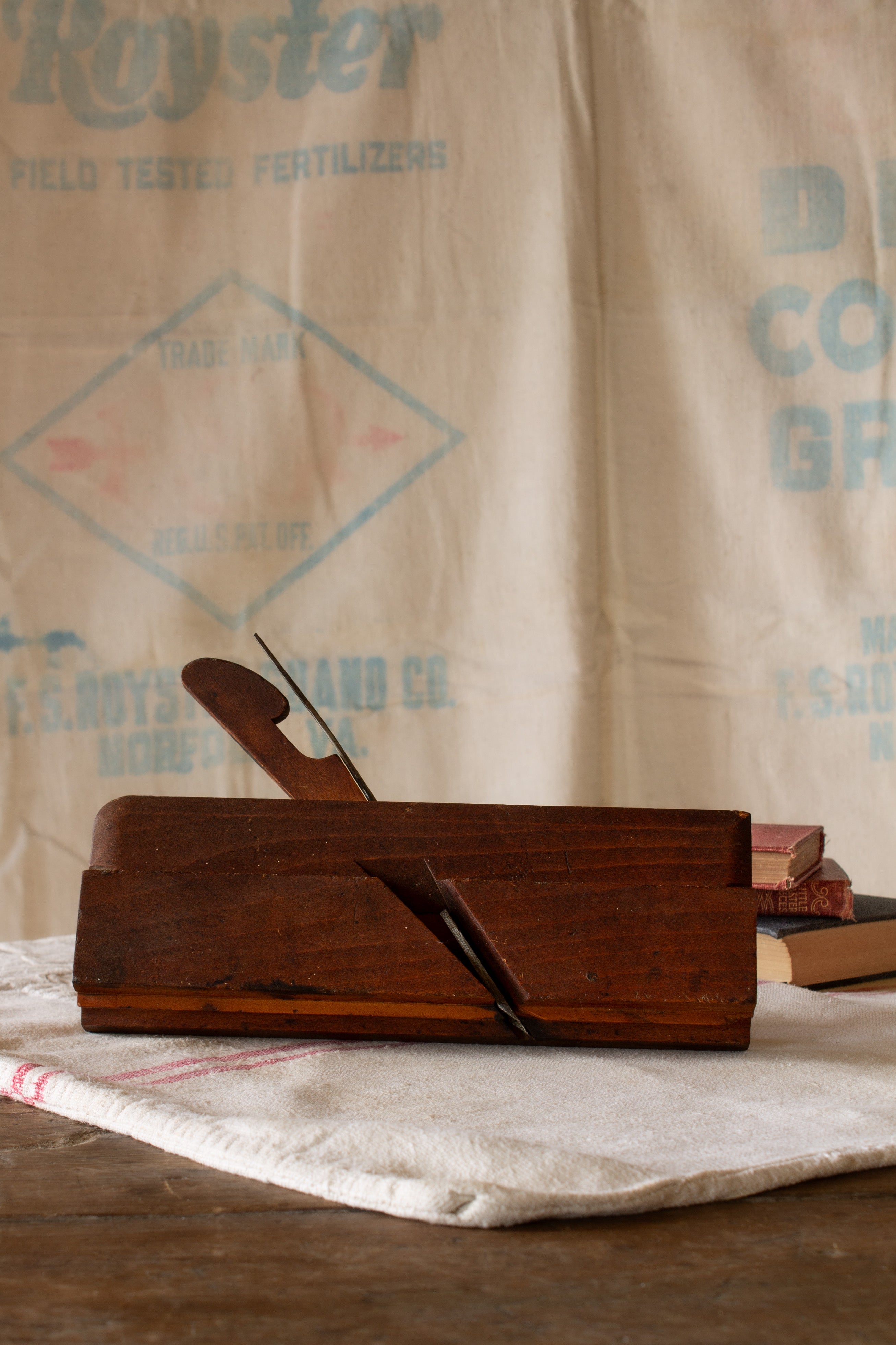 Antique wooden molding plane with warm worn wood body, original wedge, metal iron blade, and old woodworking tool patina