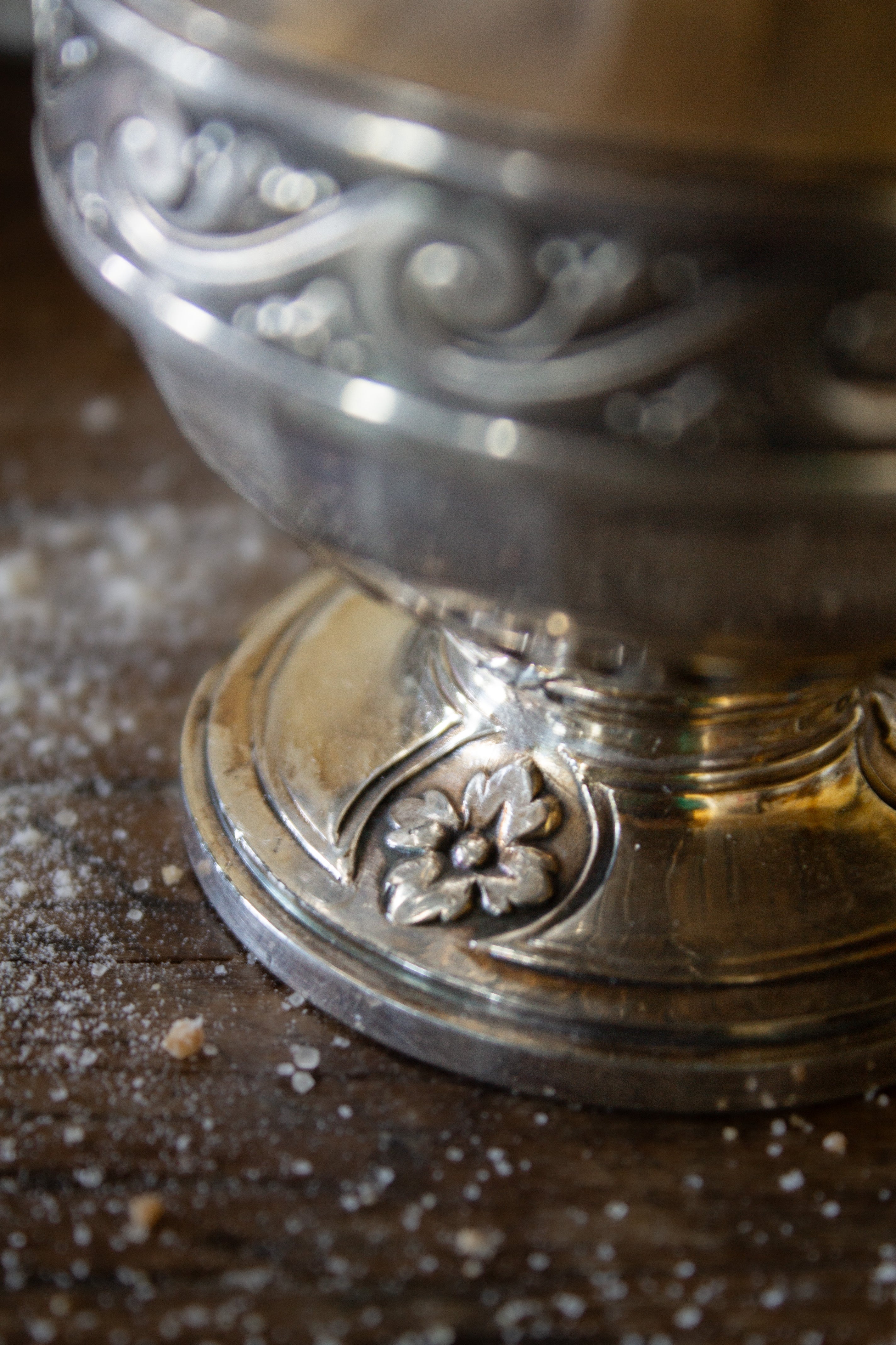 Detail of the pedestal foot and floral medallion decoration on a French Gallia silver-plated sugar caster.