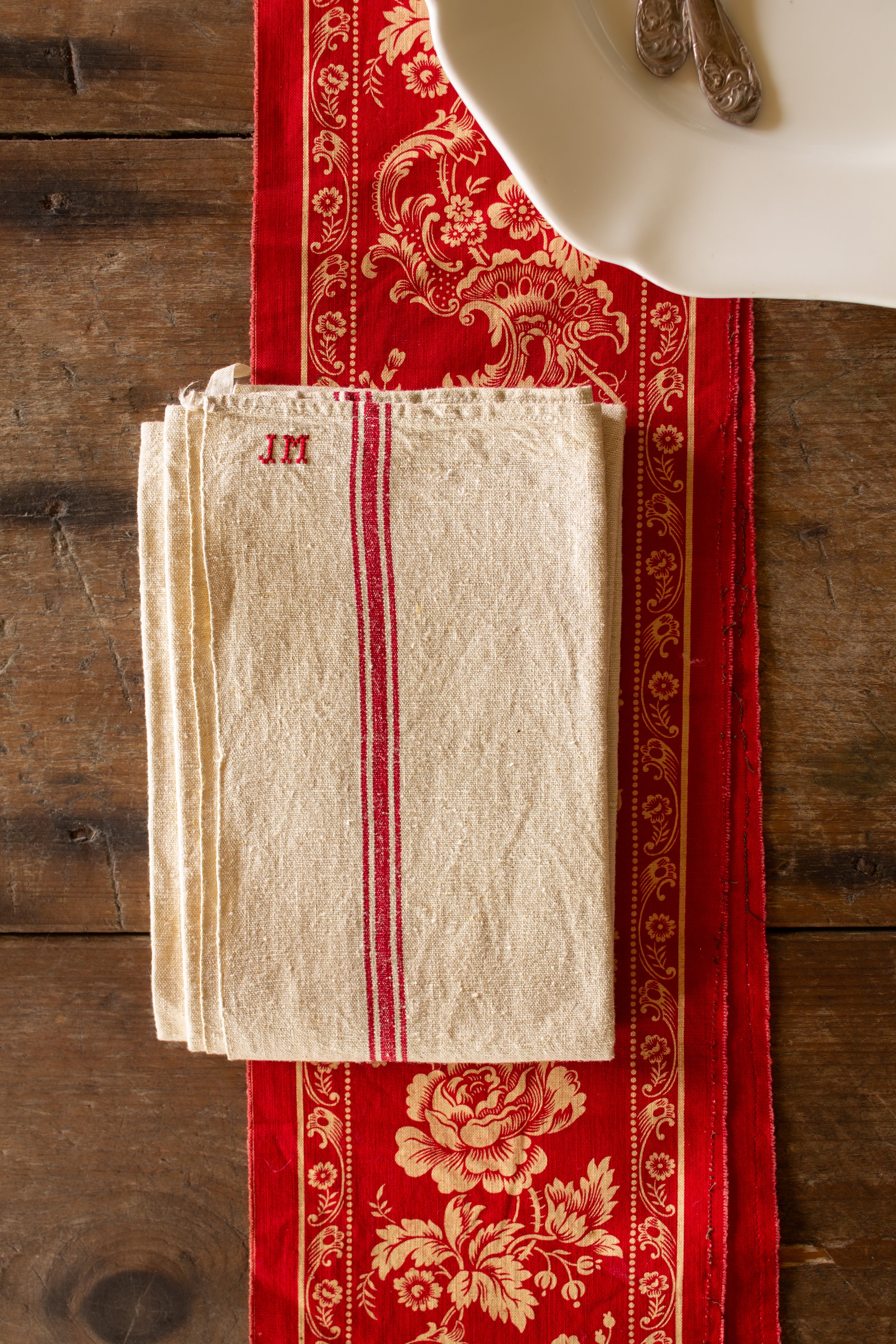 Antique French JM monogrammed red stripe linen torchon sourced in the French provinces with cream linen ground and one hanging loop.