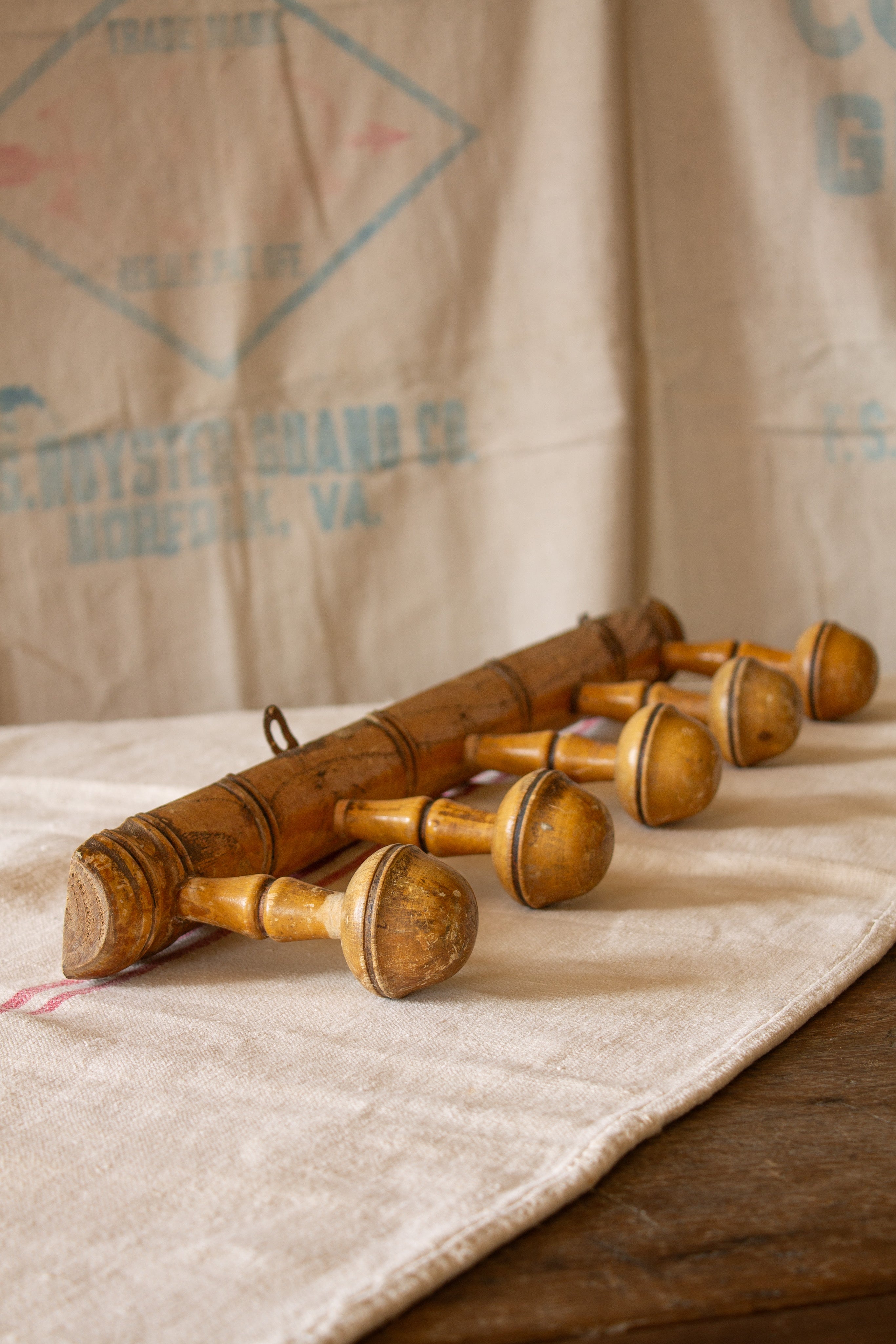 Vintage French turned wood five-peg coat rack sourced in Paris with warm honeyed finish, rounded pegs, and rustic patina.