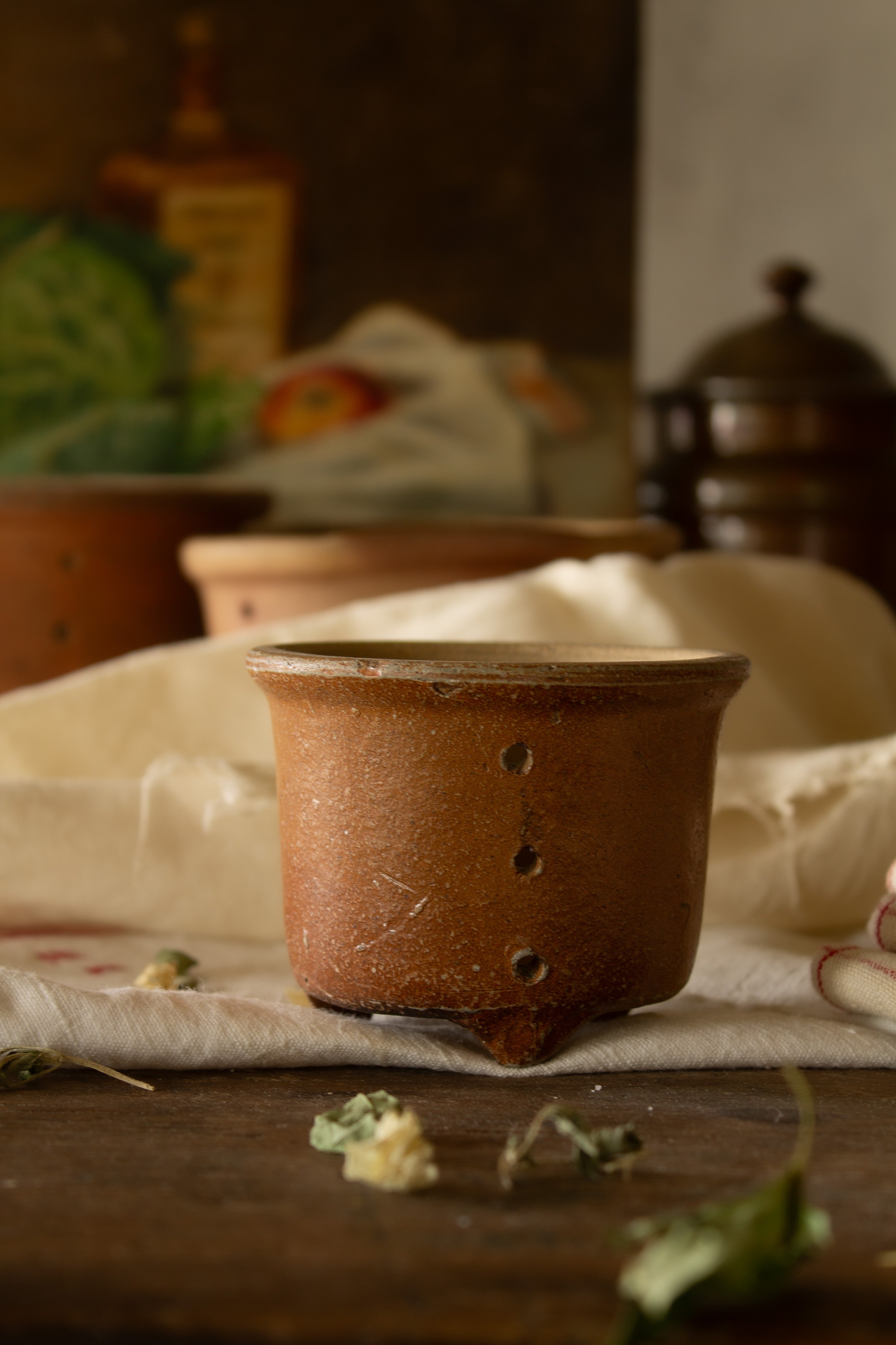 Petite antique French three-footed faisselle with perforated sides and softly aged earthenware surface.