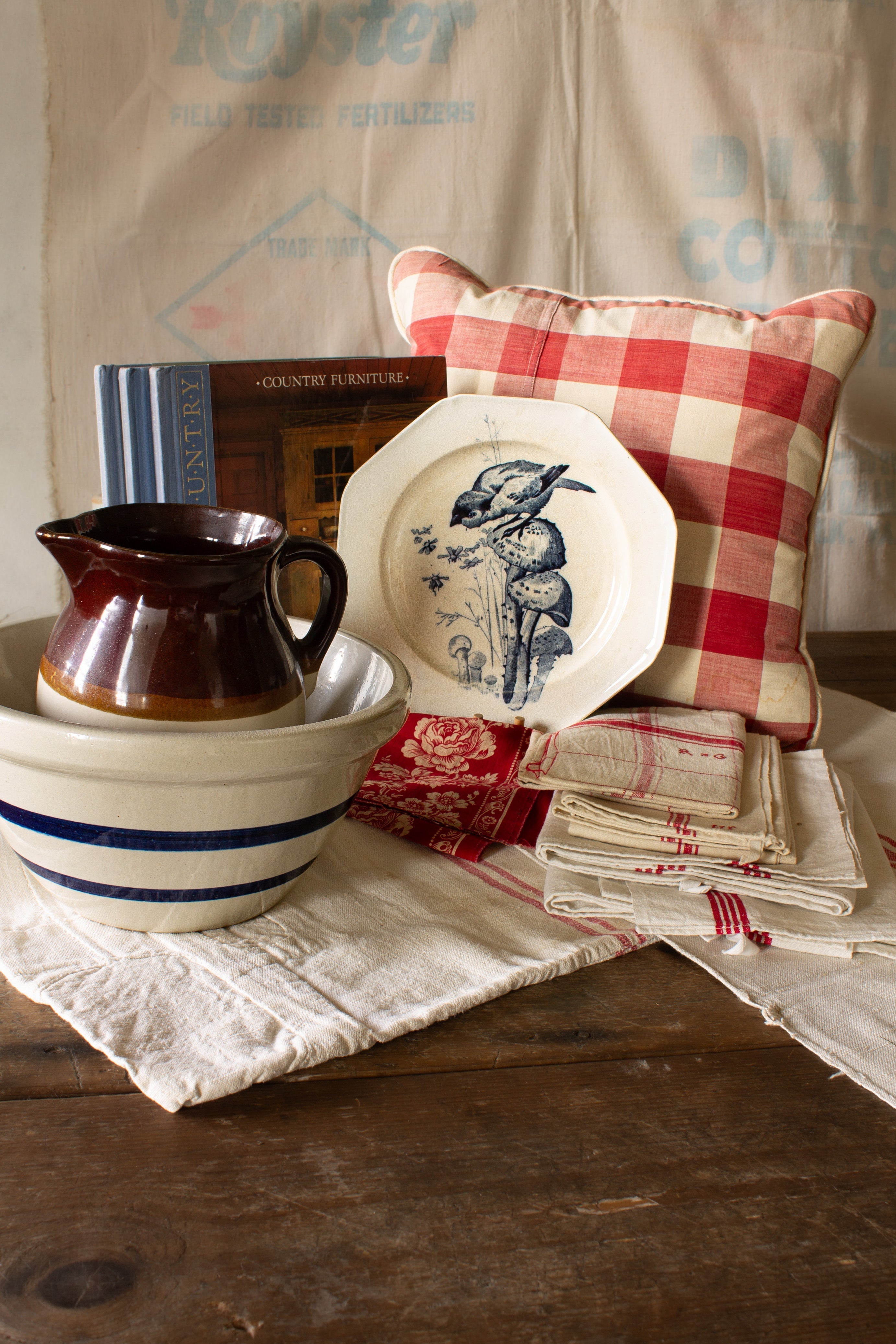The Linen & the Land collection header featuring antique French Vichy check linen, blue and white transferware, and striped stoneware styled for a collected country home.