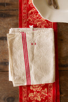 Antique French red stripe linen torchon with hand-embroidered HA monogram, hanging loops, and natural cream linen ground.