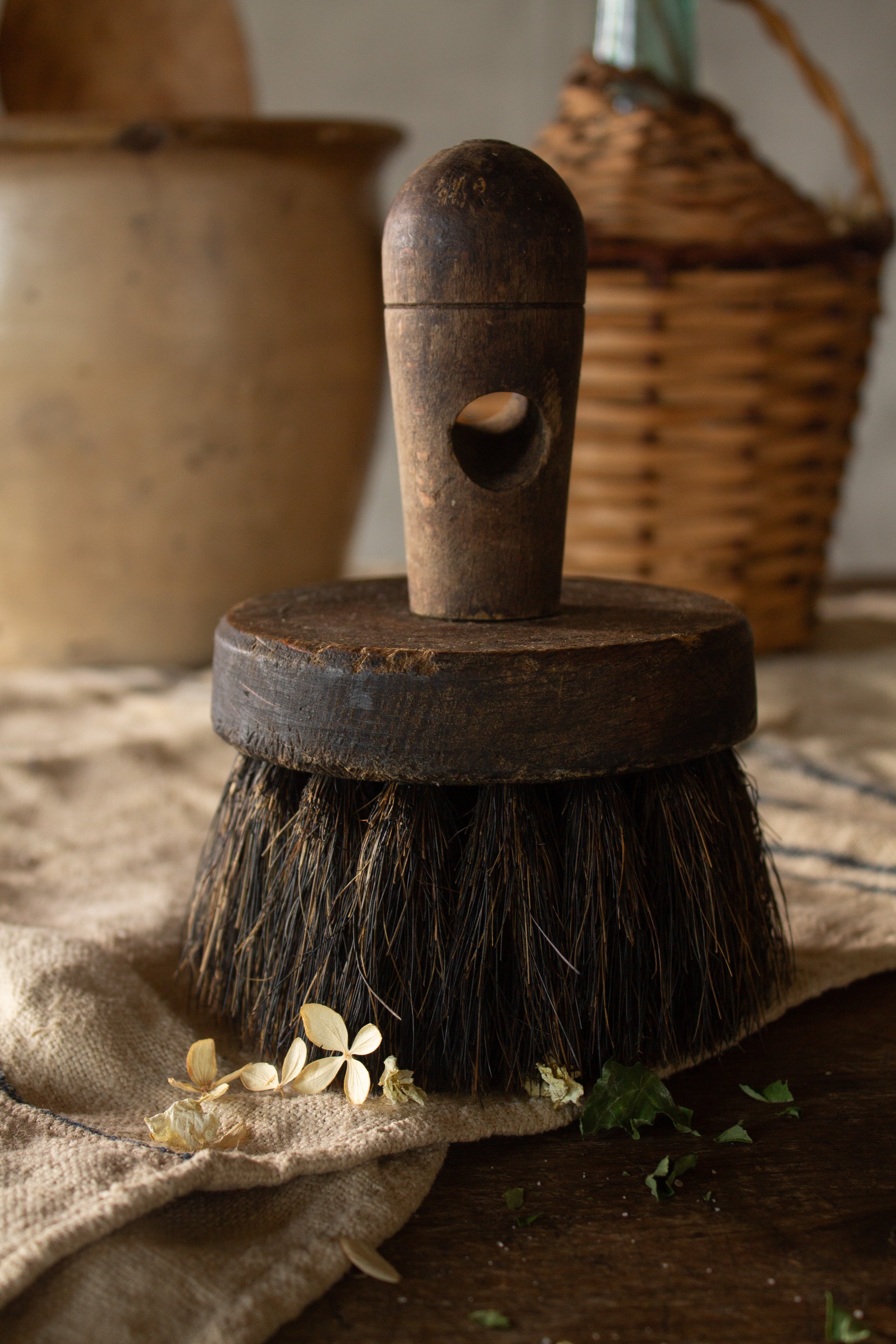Antique French horsehair work brush with dark wooden handle and round bristles.