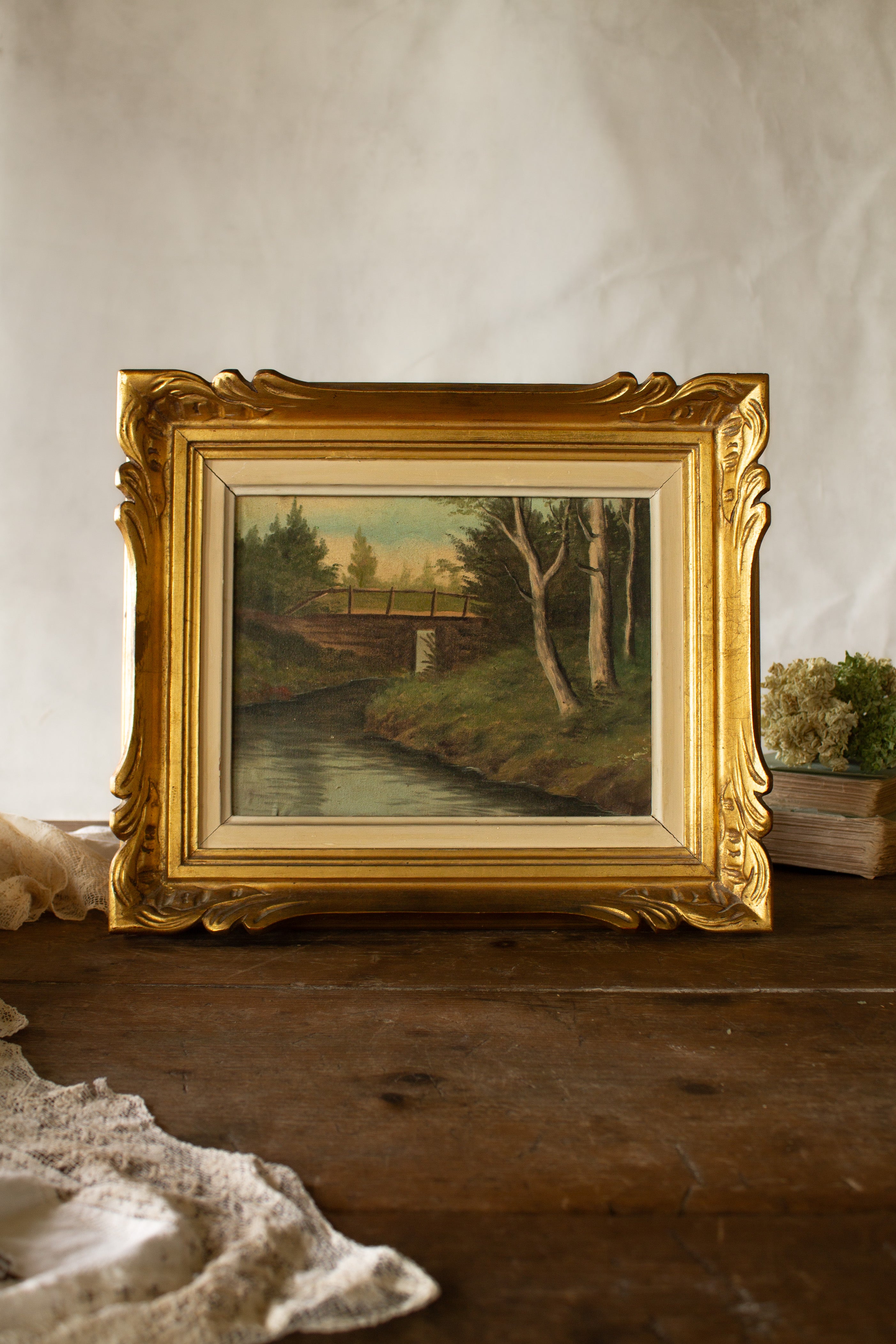 Antique French oil landscape in gilt palmette frame with relined canvas, riverside scene, and old Marseille label on back.