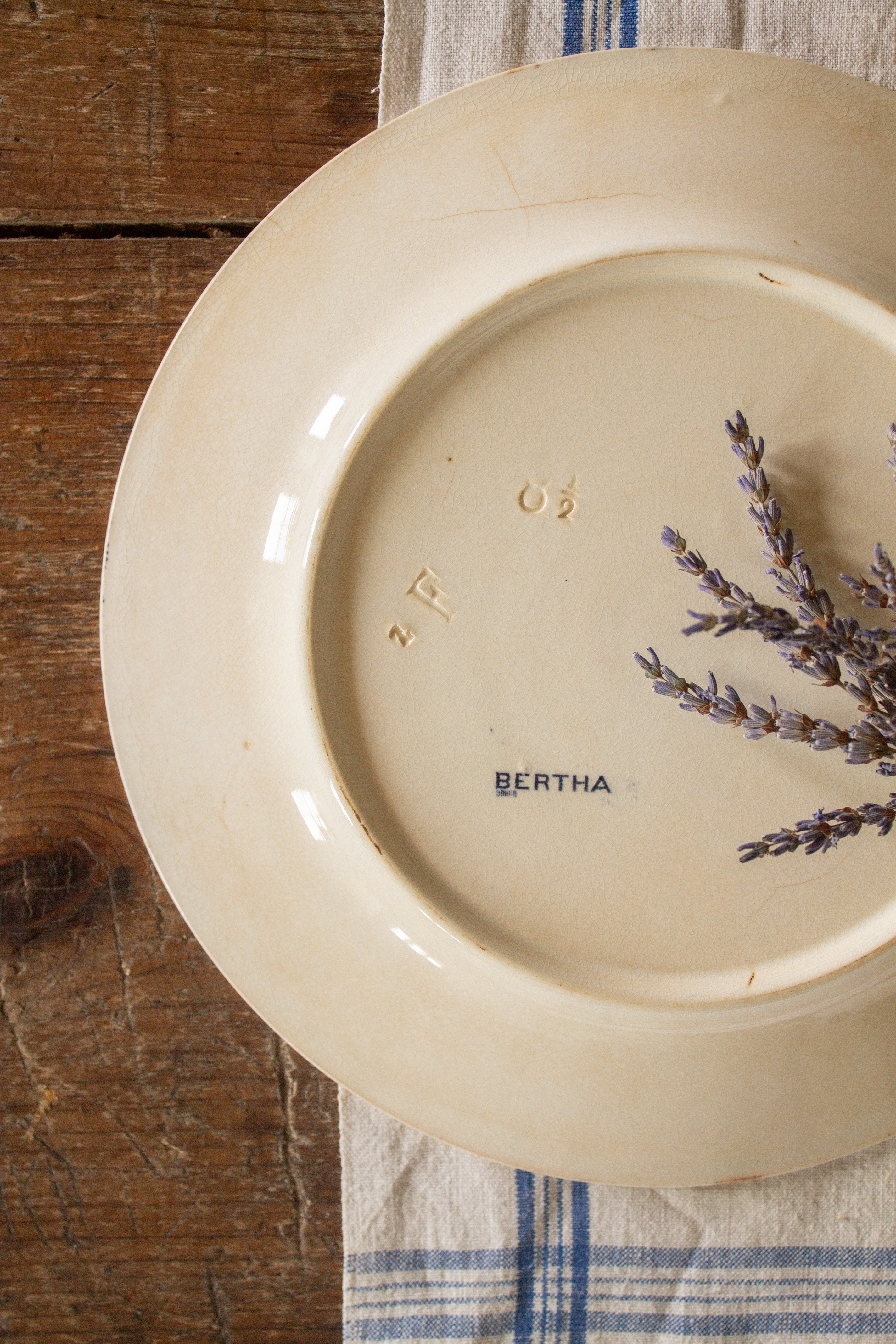 Back of antique Sarreguemines Bertha plate showing BERTHA stamp, impressed marks, crazing, and ivory glaze.