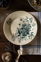 Antique French Terre de Feu de Grigny plate with aged blue-green floral transferware on a warm cream ground.