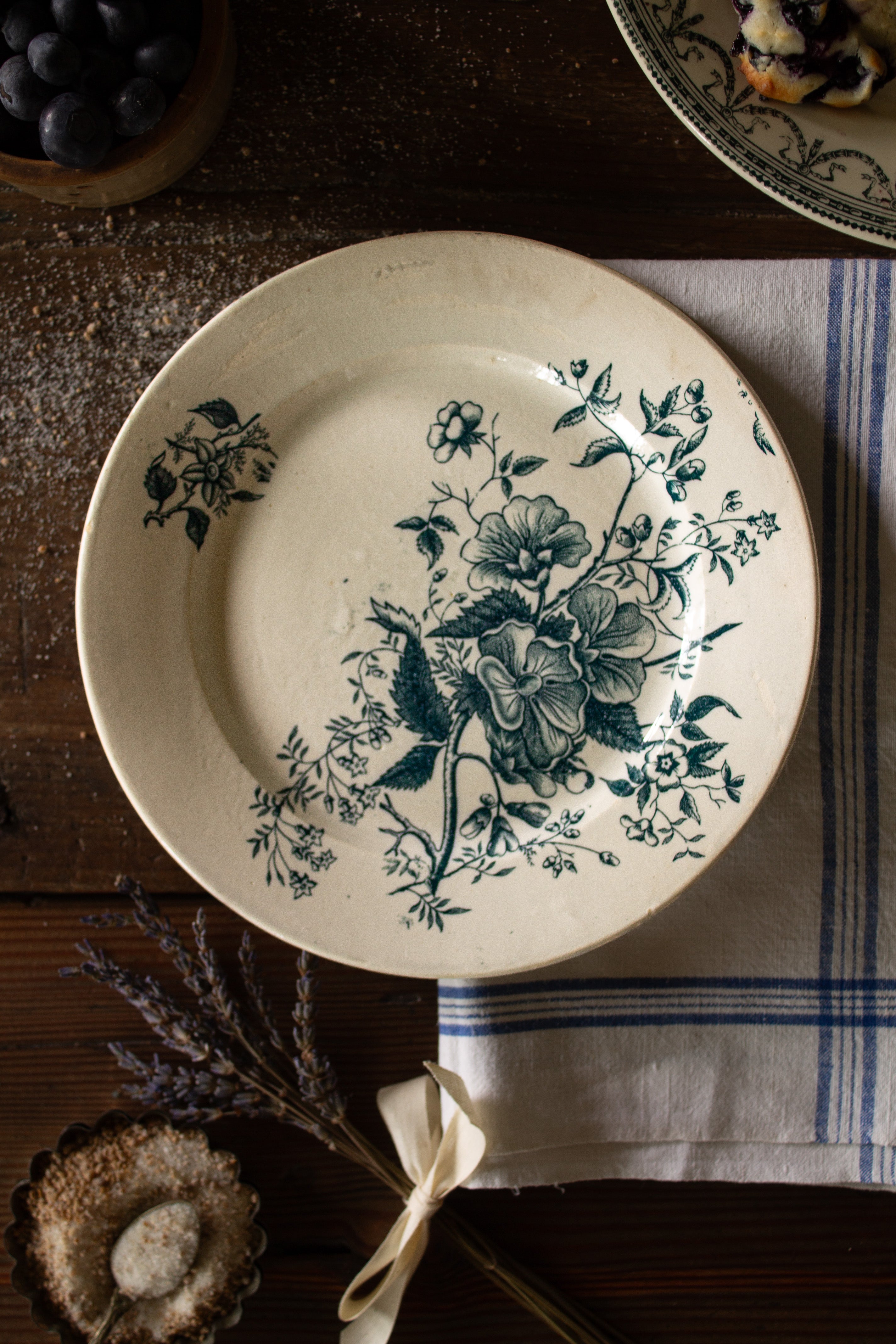 Antique French Terre de Feu de Grigny plate with aged blue-green floral transferware on a warm cream ground.