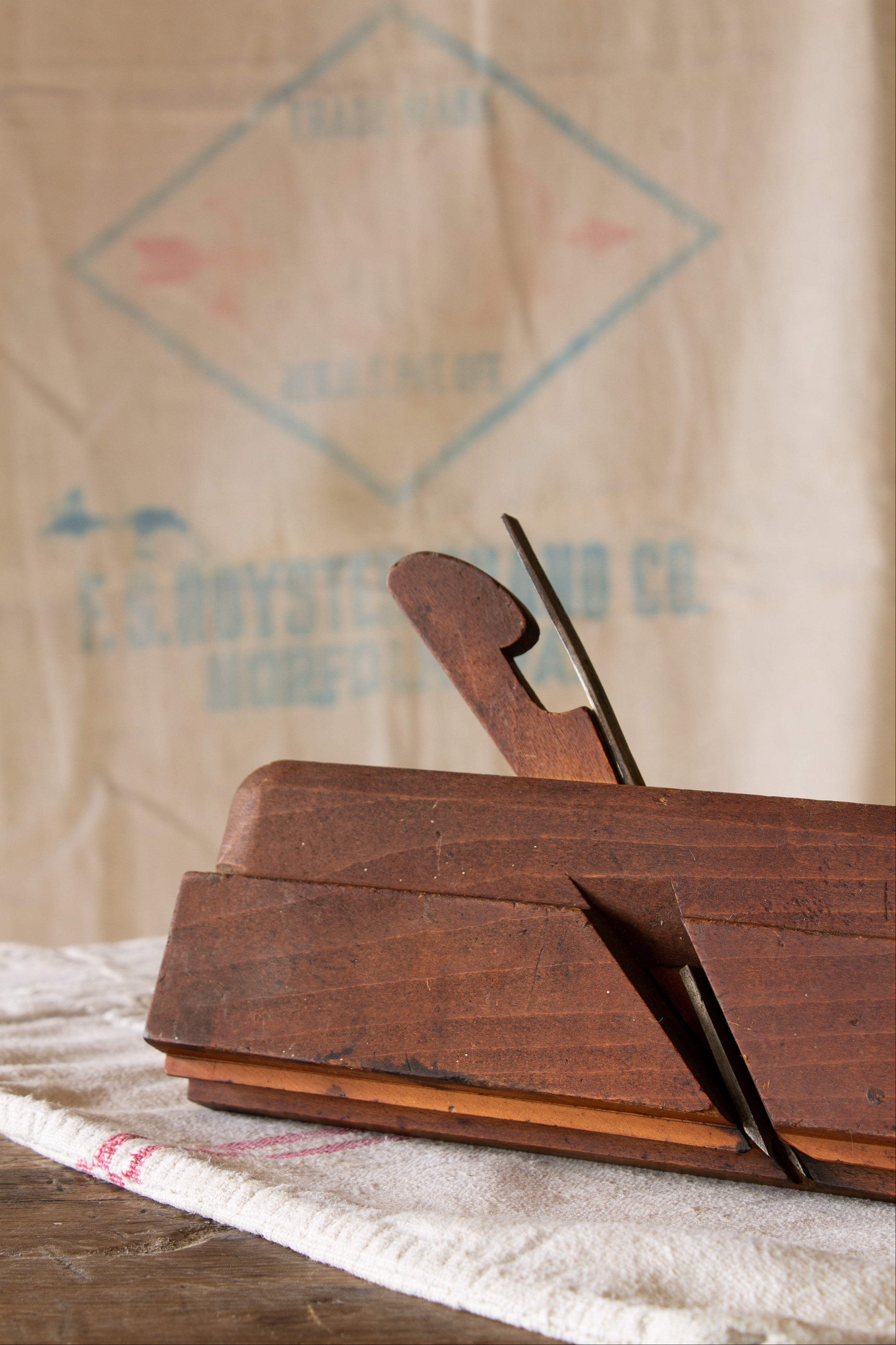 Antique wooden molding plane with warm worn wood body, original wedge, metal iron blade, and old woodworking tool patina