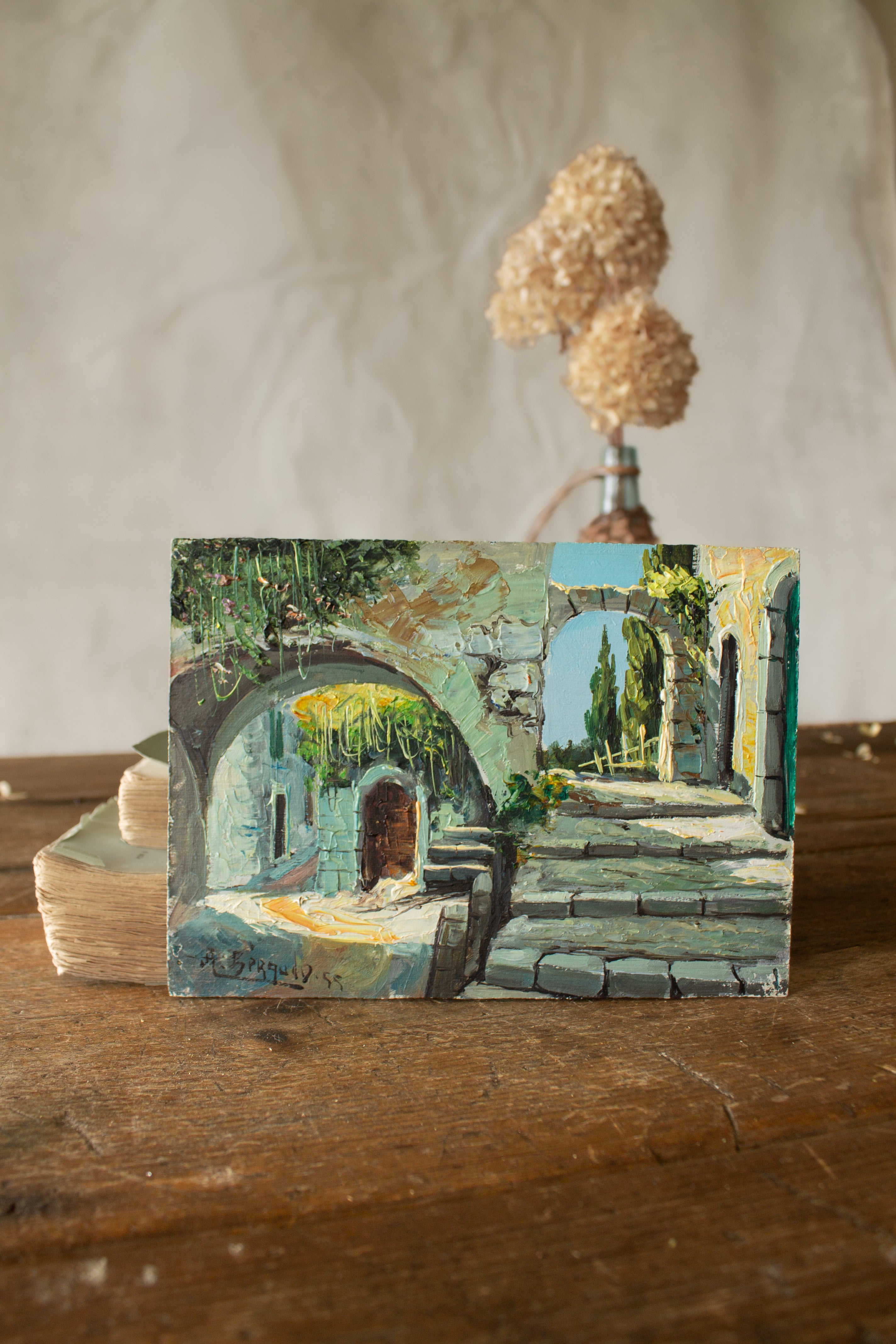 Mid-century French impasto courtyard painting dated 1955 with stone arches, steps, sunlight, greenery, and bright blue and green tones.