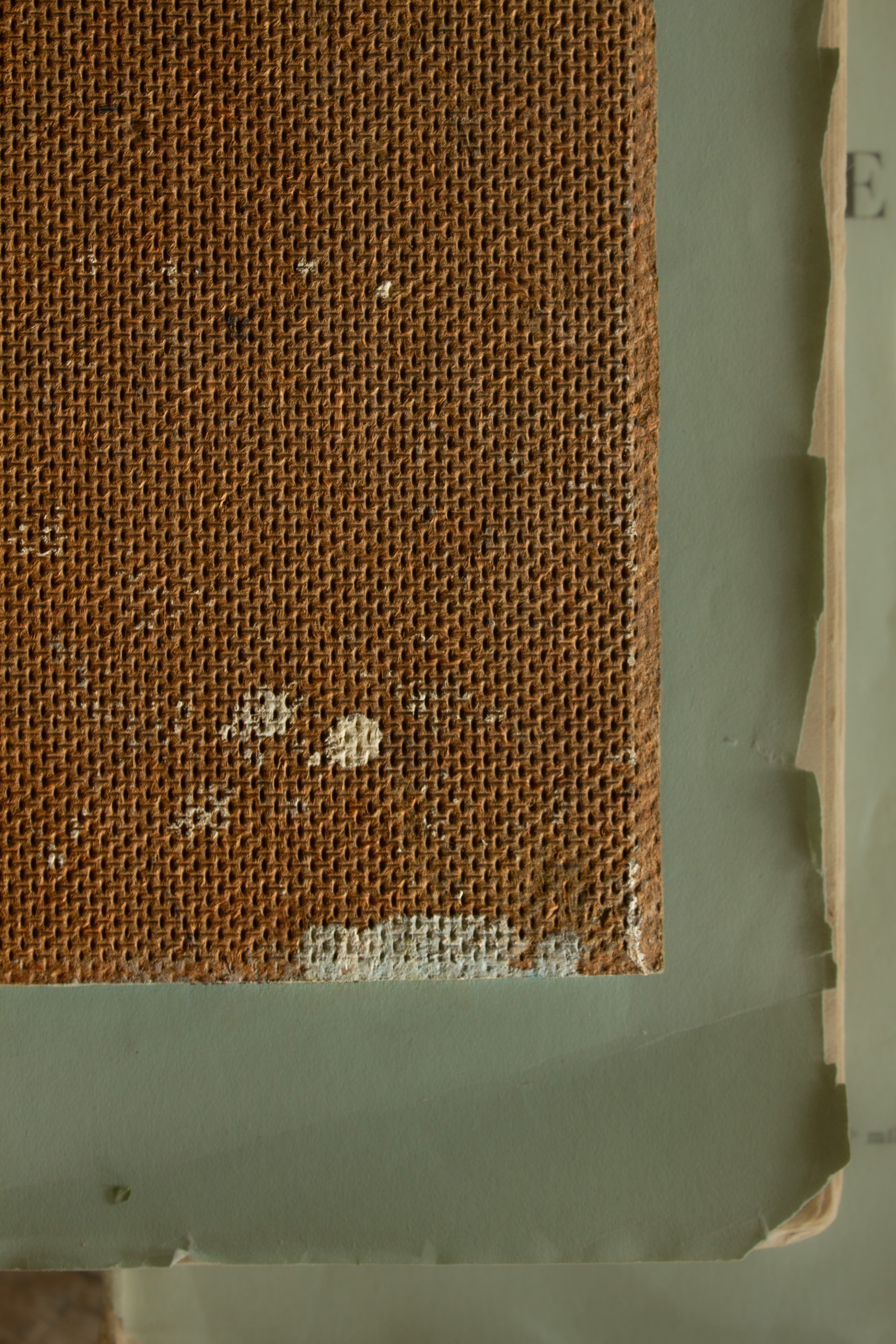 Back of a small vintage painting on board showing age, texture, and wear from earlier use.