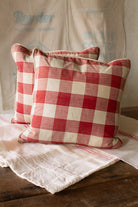 Pair of handmade pillows made from antique French Vichy check textile from the collection of June K. Laval, with softened red and cream checks, cream piping, down feather inserts, and timeworn French country textile character.