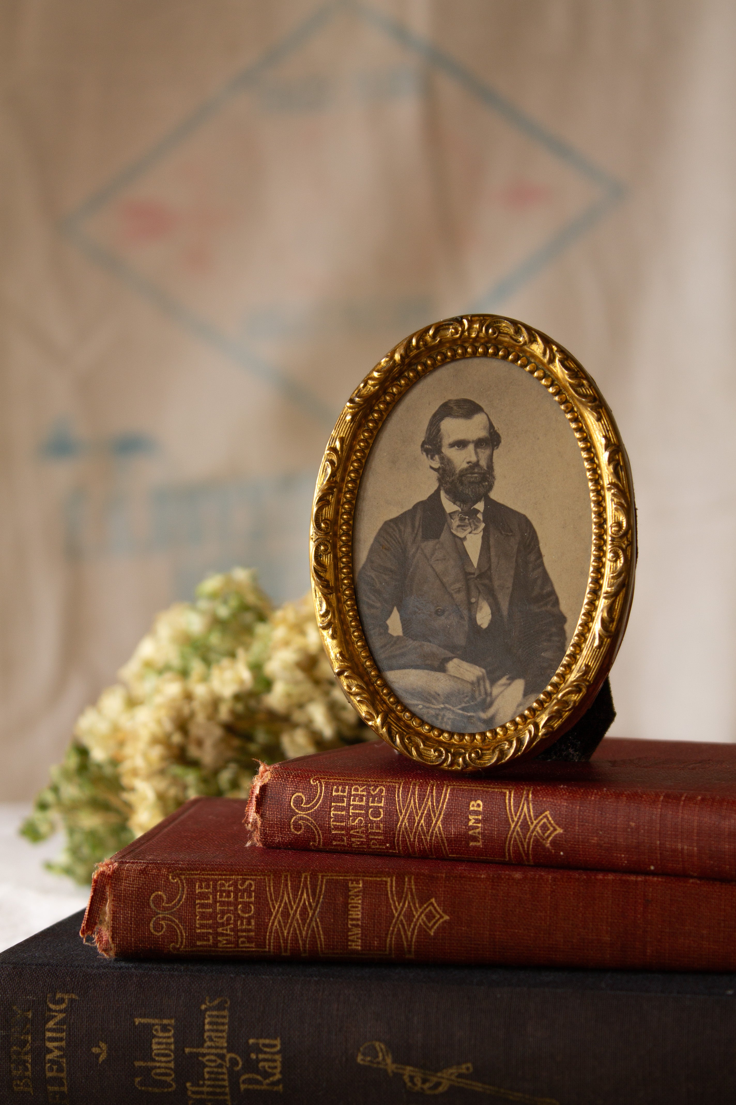 Small antique French gilt brass oval portrait frame with beaded trim, scroll detail, wavy glass, and later fabric easel back