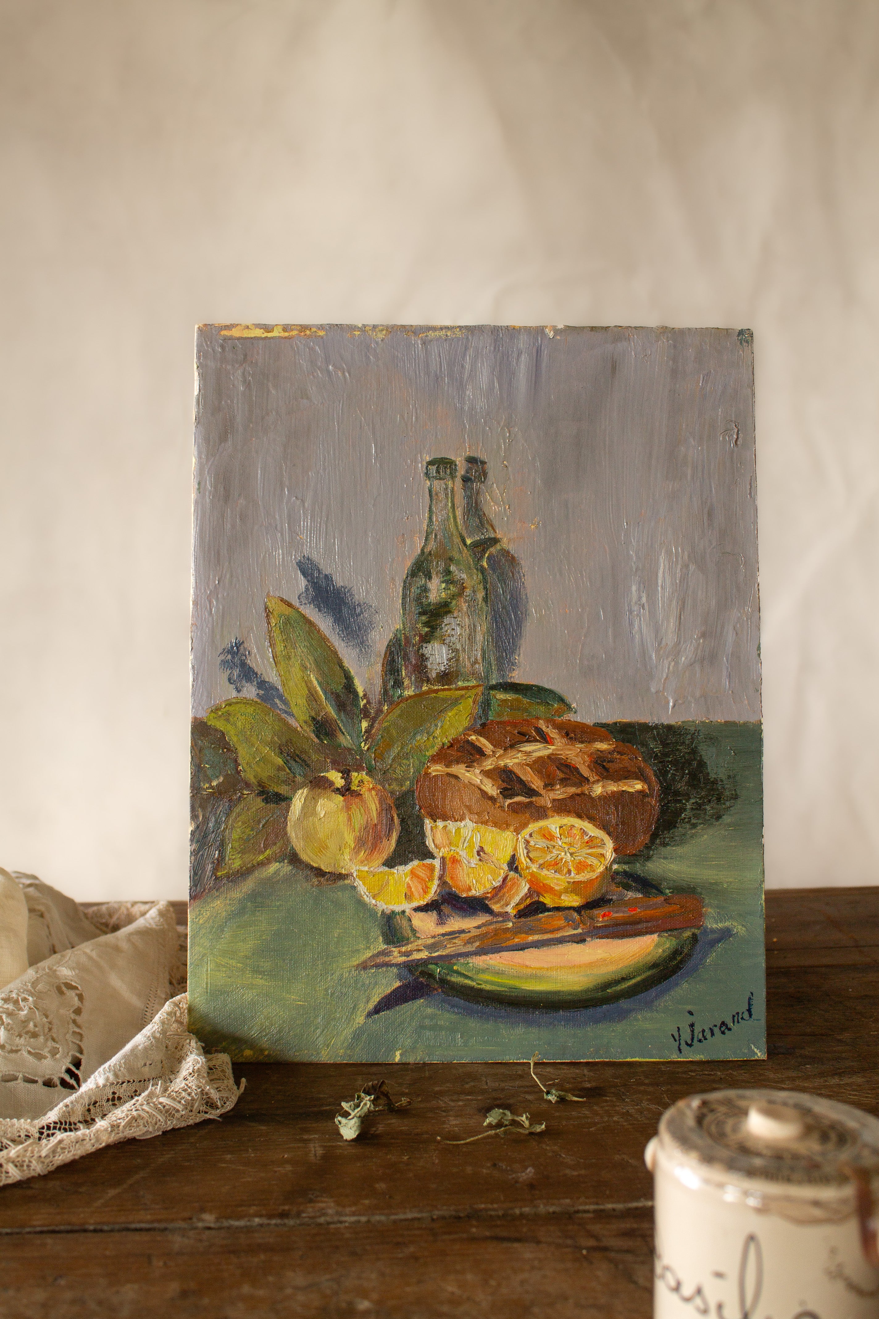Vintage French citrus still life painting on carton entoilé with oranges, lemons, green bottle, leafy stems, and textured brushwork.