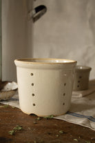 Vintage French glazed stoneware faisselle cheese mold with pierced drainage holes and stamped 12 on the base, sourced in France.
