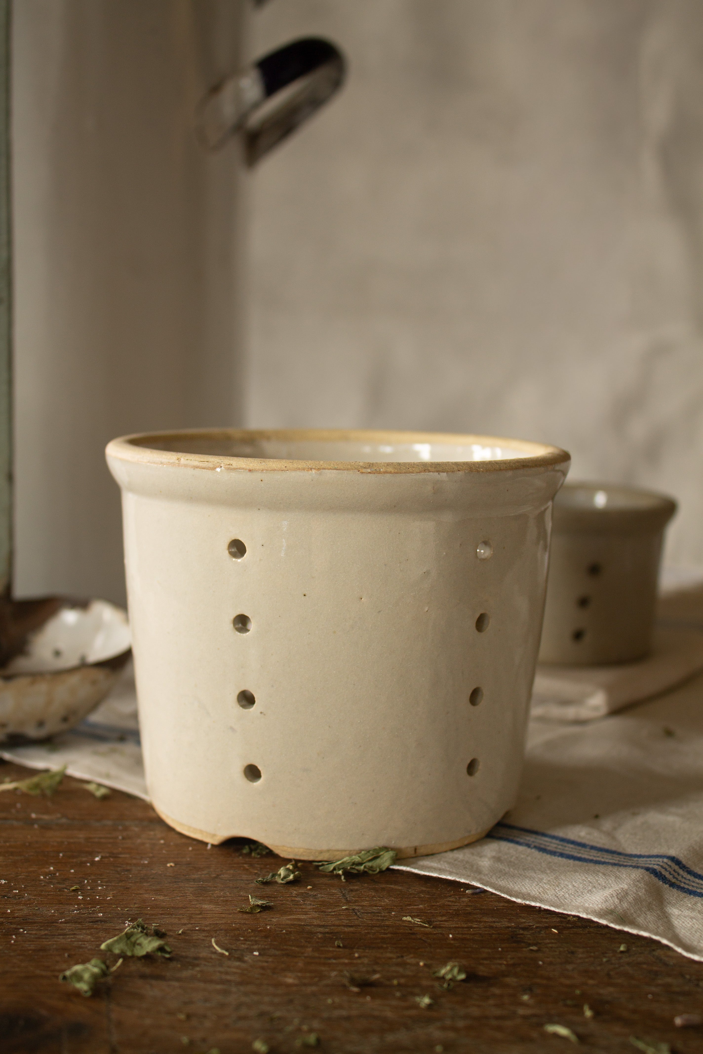 Vintage French glazed stoneware faisselle cheese mold with pierced drainage holes and stamped 12 on the base, sourced in France.