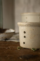 Vintage French stoneware faisselle cheese mold with pierced drainage holes and speckled beige glaze, sourced in France.