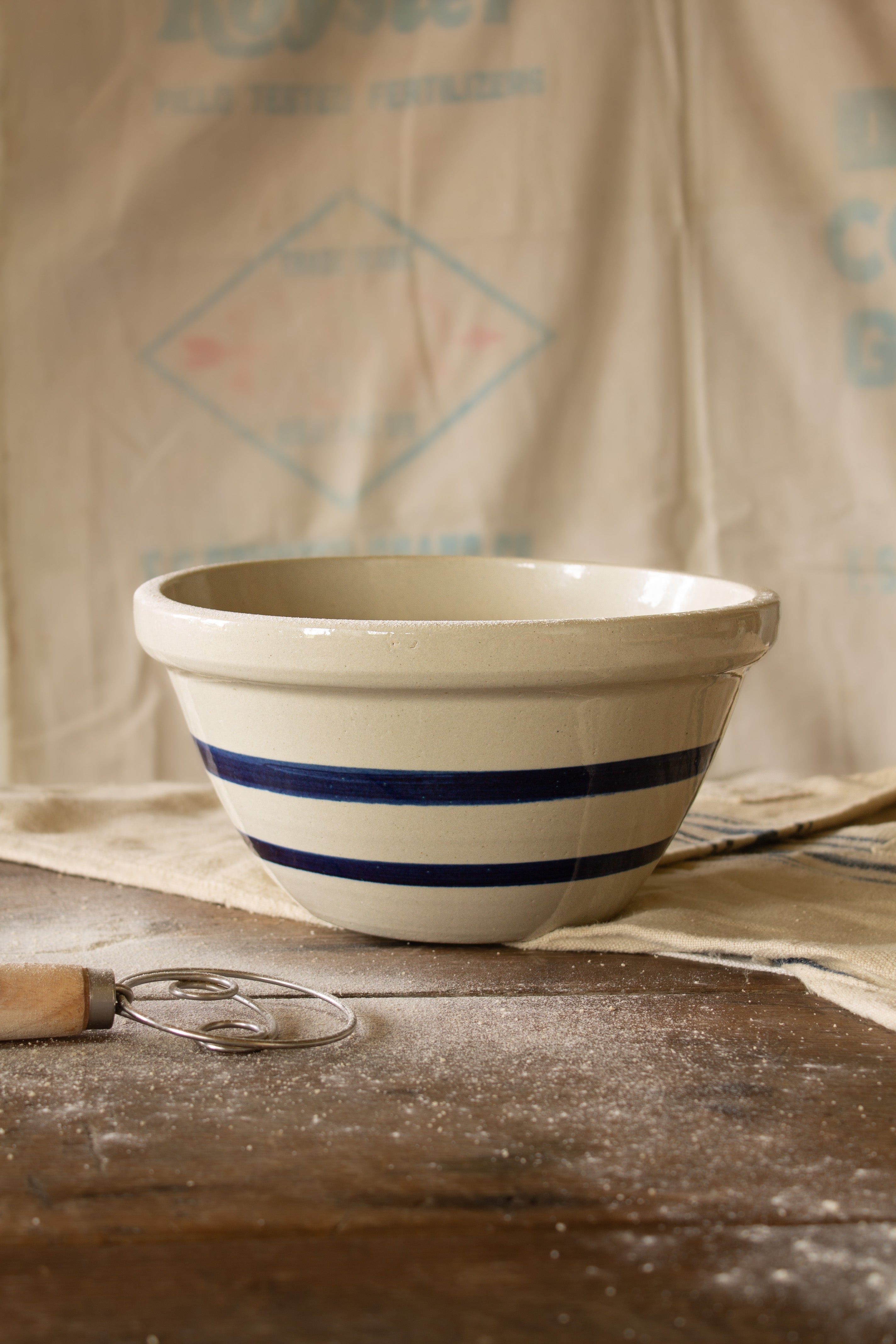 Vintage Robinson Ransbottom blue stripe stoneware mixing bowl from Roseville Ohio with heavy cream body, deep blue bands, and rolled rim.